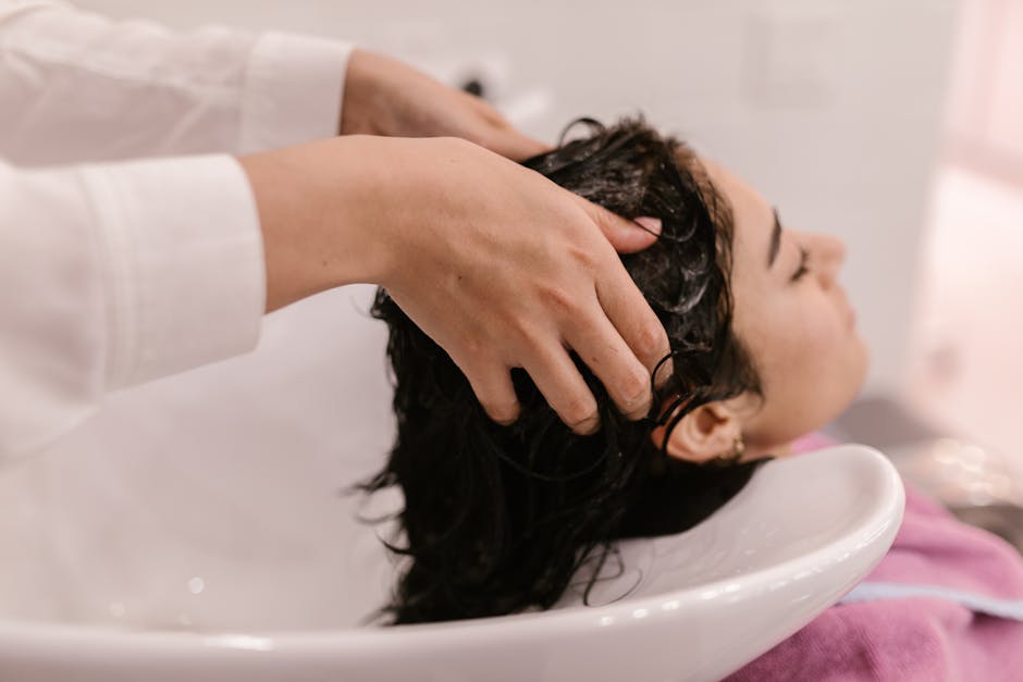 A woman enjoys a relaxing hair wash at a salon. Captured in a cozy indoor setting